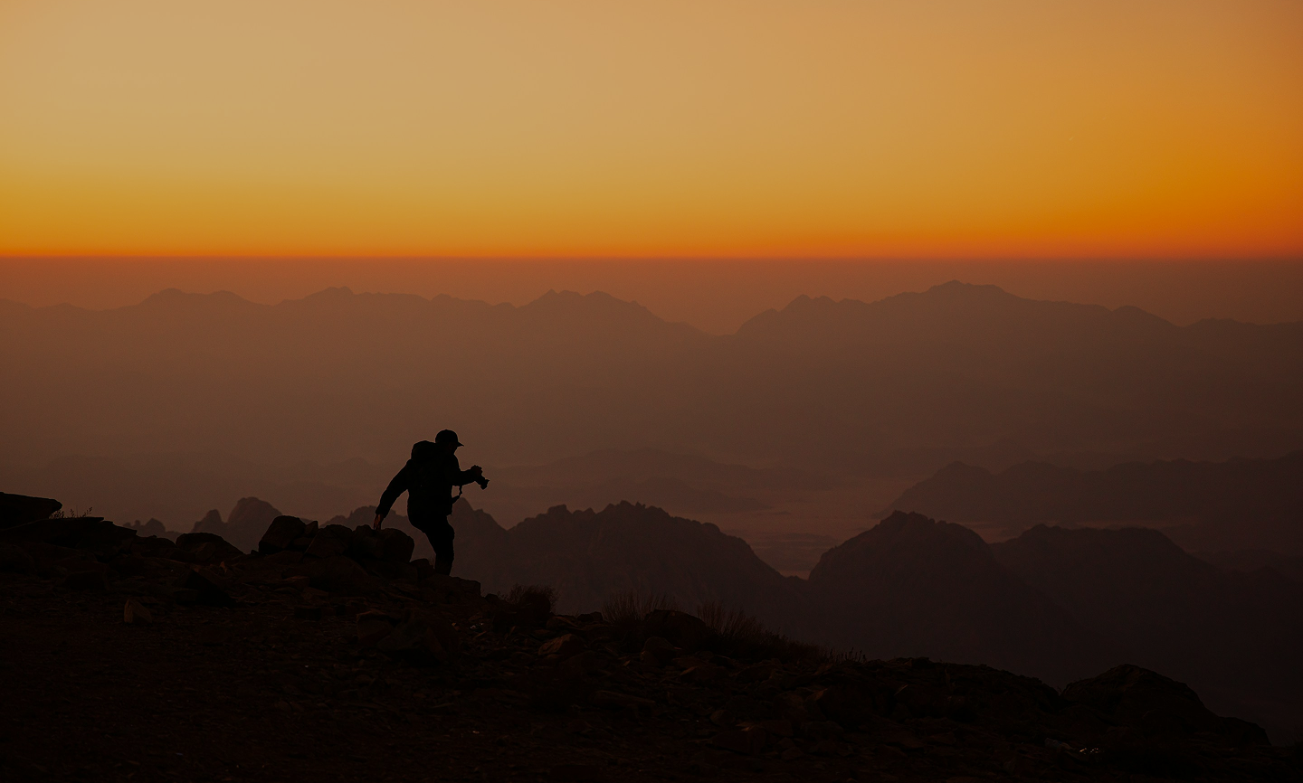 People standing on mountain at sunset